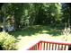 Expansive backyard featuring lush greenery, mature trees, and a charming swing set, perfect for outdoor relaxation at 5152 Suggs St, Powder Springs, GA 30127