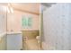 Bathroom features a shower with floral curtain, a window, and neutral decor at 5152 Suggs St, Powder Springs, GA 30127