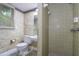 Bathroom with walk-in tiled shower, patterned wallpaper, and a window for natural light at 5152 Suggs St, Powder Springs, GA 30127