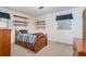 Bedroom with carpeted floors, a wooden bed with built-in storage, and mounted shelves with a neutral paint palette at 5152 Suggs St, Powder Springs, GA 30127