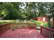 Wooden deck overlooking a spacious, tree-lined backyard with a charming storage shed at 5152 Suggs St, Powder Springs, GA 30127