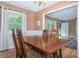 Traditional dining room with a large wooden table, chandelier lighting, and views into the living space at 5152 Suggs St, Powder Springs, GA 30127