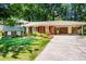 Inviting home featuring a well-manicured lawn, mature landscaping, and a convenient covered carport at 5152 Suggs St, Powder Springs, GA 30127