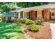 Close-up of a well-maintained home featuring brick accents and colorful landscaping in a lush, green yard at 5152 Suggs St, Powder Springs, GA 30127