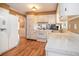 Functional kitchen featuring white cabinets, clean appliances, and hardwood floors with easy access to other rooms at 5152 Suggs St, Powder Springs, GA 30127