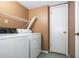 Functional laundry room featuring a washer, dryer, wire shelving, and door at 5152 Suggs St, Powder Springs, GA 30127