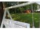 Close-up of a classic white swing set in a leafy backyard, inviting relaxation and leisure at 5152 Suggs St, Powder Springs, GA 30127