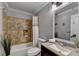 Cozy bathroom featuring a shower-tub combo with stone-look tile surround and vanity sink at 708 Edgeley Ln, Lawrenceville, GA 30044