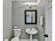The bathroom has a pedestal sink, decorative mirror, and toilet with a towel rack on the side at 708 Edgeley Ln, Lawrenceville, GA 30044