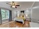 Bright bedroom featuring a ceiling fan and large windows with wooded views at 708 Edgeley Ln, Lawrenceville, GA 30044