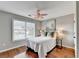 Neutral bedroom featuring hardwood floors, a window view, and modern decorative lighting at 708 Edgeley Ln, Lawrenceville, GA 30044