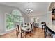 The dining room is illuminated by natural light and features hardwood floors, a modern table, and a stylish chandelier at 708 Edgeley Ln, Lawrenceville, GA 30044