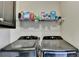 The laundry room has a modern washer and dryer set with detergent and supplies displayed above at 708 Edgeley Ln, Lawrenceville, GA 30044