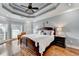 Spacious main bedroom featuring tray ceilings, hardwood floors, and large windows at 708 Edgeley Ln, Lawrenceville, GA 30044