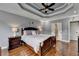 Charming main bedroom featuring a decorative tray ceiling, a fan and hardwood floors at 708 Edgeley Ln, Lawrenceville, GA 30044