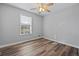Bright bedroom featuring modern flooring, a ceiling fan, and a large window allowing for natural light at 140 Moseley Dr, Stockbridge, GA 30281