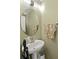 Well-lit half bathroom with a pedestal sink, decorative mirror, and neutral wall color at 1955 Shawn Wayne Se Cir, Atlanta, GA 30316