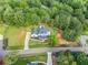 Expansive aerial view of the property, featuring a pool, spacious lawn, and mature trees at 200 Whispering Pines Dr, Woodstock, GA 30188