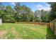 Spacious, green backyard featuring a neat lawn and a newly installed wooden fence for privacy at 200 Whispering Pines Dr, Woodstock, GA 30188