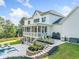 Spacious backyard with a pool, stone patio, lush landscaping, and screened porch at 200 Whispering Pines Dr, Woodstock, GA 30188