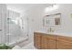 Modern bathroom with a glass-enclosed shower, marble tile, and wood vanity at 200 Whispering Pines Dr, Woodstock, GA 30188
