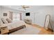 Cozy bedroom featuring wood floors, a ceiling fan, television, and light-blocking curtains at 200 Whispering Pines Dr, Woodstock, GA 30188
