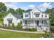 Beautiful white two-story home featuring a welcoming front porch and manicured landscaping at 200 Whispering Pines Dr, Woodstock, GA 30188