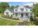 Stunning white two-story home with a covered front porch and professionally landscaped yard at 200 Whispering Pines Dr, Woodstock, GA 30188