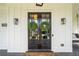 Elegant double front doors adorned with wreaths and enhanced by black sconces welcome you home at 200 Whispering Pines Dr, Woodstock, GA 30188