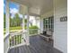 Inviting front porch featuring a cozy bench and white pillars with views of the landscaped yard at 200 Whispering Pines Dr, Woodstock, GA 30188