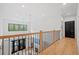 Open-concept hallway with hardwood floors and modern railing overlooking the living area at 200 Whispering Pines Dr, Woodstock, GA 30188