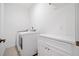 Clean and organized laundry room with a washer, dryer, and folding counter at 200 Whispering Pines Dr, Woodstock, GA 30188