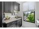Well-lit laundry room with black cabinets, countertops, sink and a window overlooking the backyard at 200 Whispering Pines Dr, Woodstock, GA 30188