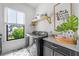 Bright laundry room with modern washer and dryer, stylish cabinets, and a view to the neighborhood at 200 Whispering Pines Dr, Woodstock, GA 30188