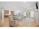 Bright living room with hardwood floors, a modern sectional sofa, and open to the kitchen at 200 Whispering Pines Dr, Woodstock, GA 30188