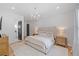 Luxurious main bedroom with elegant chandelier, textured accent wall, and stylish furnishings at 200 Whispering Pines Dr, Woodstock, GA 30188