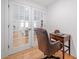 Bright home office featuring french doors, wood floors, desk, and comfortable executive chair at 200 Whispering Pines Dr, Woodstock, GA 30188