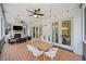 Covered patio with wood floors, ceiling fan, outdoor dining table and chairs, and a fireplace with seating at 200 Whispering Pines Dr, Woodstock, GA 30188