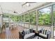 Screened-in porch with a ceiling fan, fireplace, and outdoor furniture at 200 Whispering Pines Dr, Woodstock, GA 30188