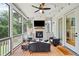 Screened-in porch with ceiling fan, fireplace, outdoor furniture, and views of backyard trees at 200 Whispering Pines Dr, Woodstock, GA 30188