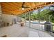 Covered patio features stone floors, brick walls, wood ceiling, and a view of the backyard swimming pool at 200 Whispering Pines Dr, Woodstock, GA 30188