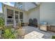 Rear stone patio featuring a grill, outdoor seating, and plants at 200 Whispering Pines Dr, Woodstock, GA 30188