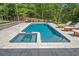Swimming pool and spa with stone paver patio, privacy fence, and mature landscaping at 200 Whispering Pines Dr, Woodstock, GA 30188