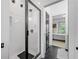 Modern walk-in shower with glass door, herringbone tile, and black hardware at 200 Whispering Pines Dr, Woodstock, GA 30188