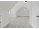 Unfinished attic featuring plush carpet flooring, a small window, and two doorways at 2430 Hemrick Rd, Cumming, GA 30041
