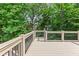 Spacious deck with black metal railings overlooking a private, tree-lined backyard at 2430 Hemrick Rd, Cumming, GA 30041