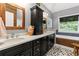 Modern bathroom with dual sinks, black cabinets, wood framed mirrors, and mosaic tile at 2430 Hemrick Rd, Cumming, GA 30041