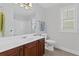 Bathroom featuring a wood vanity, large mirror, tile floors, window with blinds and toilet at 2430 Hemrick Rd, Cumming, GA 30041