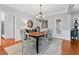 Formal dining room with wainscoting, hardwood floors and stylish chandelier at 2430 Hemrick Rd, Cumming, GA 30041