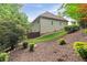 Exterior view of a two-story home with tan siding, set on a landscaped lot with mature trees at 2430 Hemrick Rd, Cumming, GA 30041